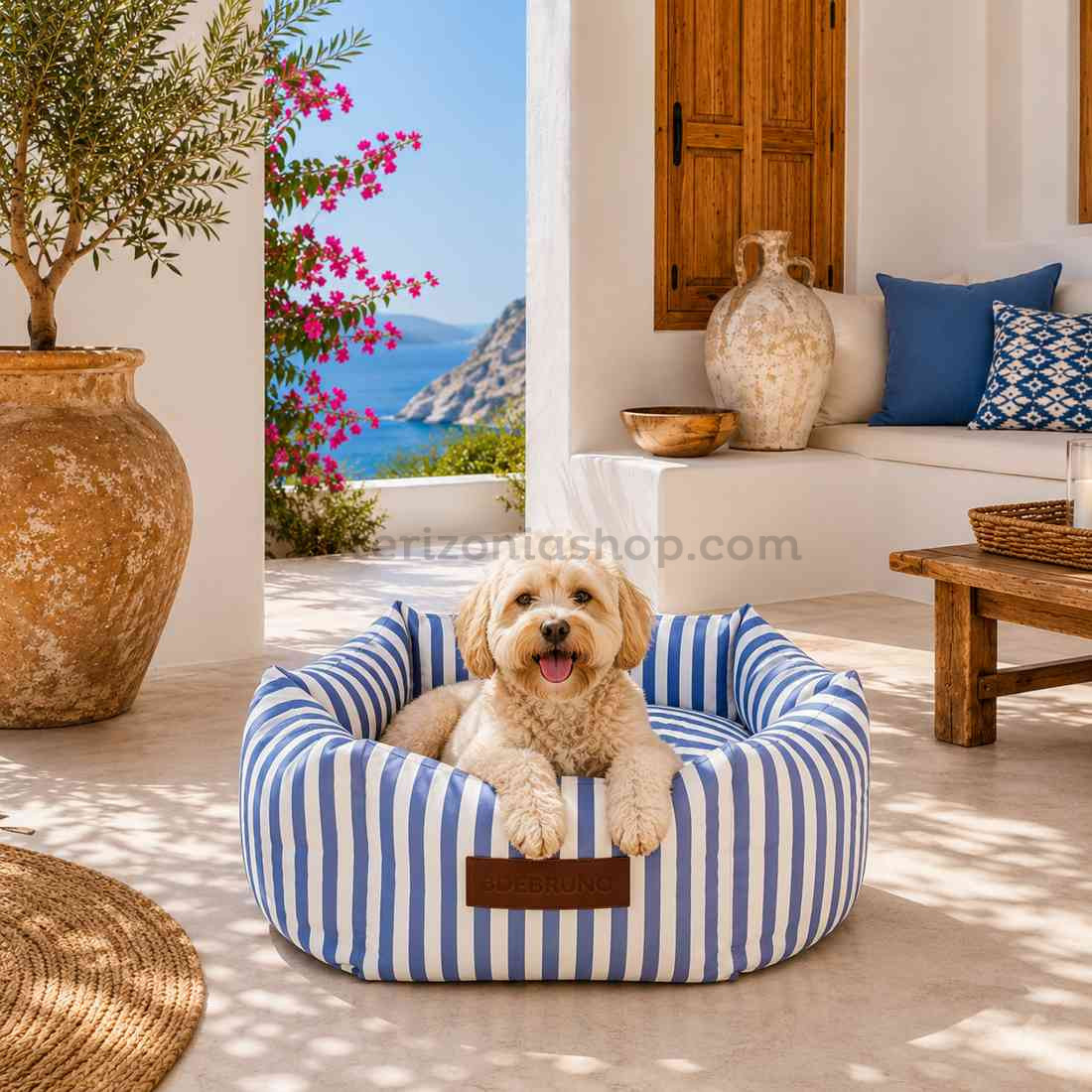 Perro pequeño descansando en cama mediterránea de rayas azules viscoelástica desenfundable en una casa estilo Ibiza frente al mar