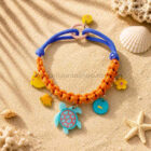 Collar con charms para perro modelo Océano sobre arena de playa