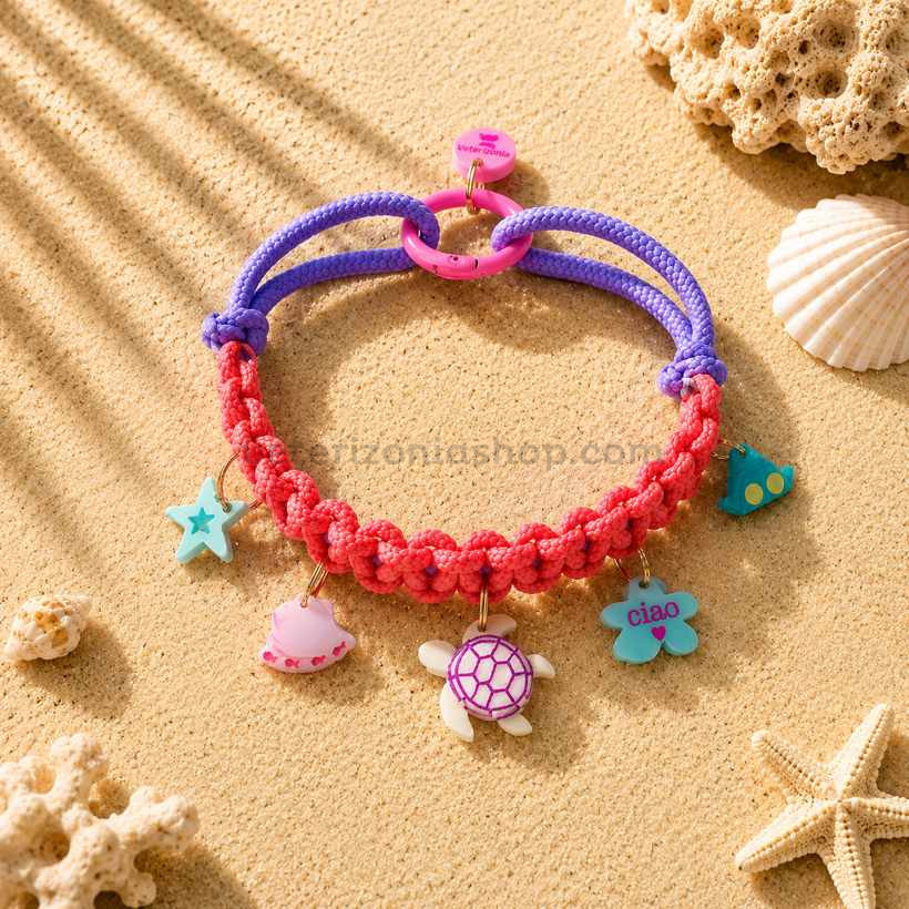 Collar con charms para perros pequeños modelo Océano Coral en tonos coral y lila con colgantes marinos decorativos sobre fondo arena estilo verano