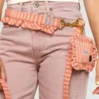 Porta bolsas para perro rayas coral sujeto a la correa mediante mosquetón metálico dorado.